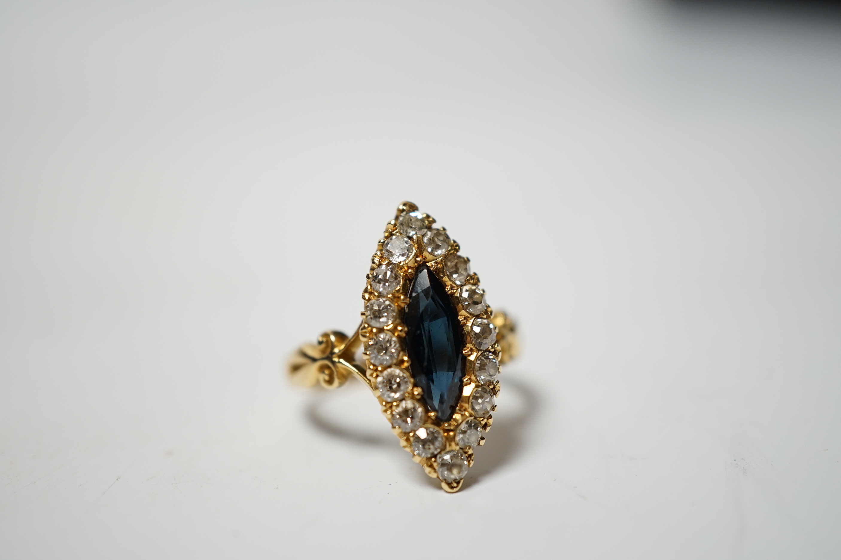 An Edwardian 18ct gold, sapphire and diamond cluster set marquise shaped ring, size K, gross weight 4.2 grams.